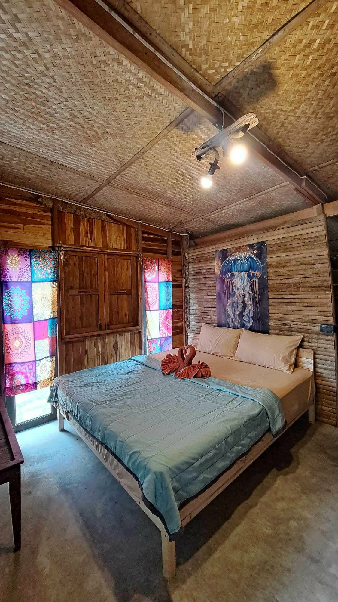 Full Suite bedroom with bamboo-woven ceiling and local artwork